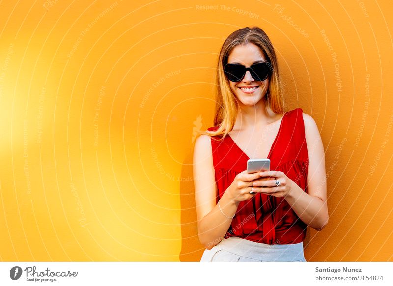Porträt einer schönen jungen Frau mit Handy auf der Straße. Telefon Glück Mobile Jugendliche Wand Texten Tippen PDA benutzend Lächeln Dame attraktiv