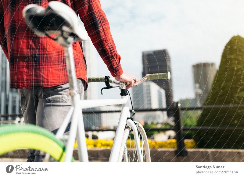 Junger Mann auf dem Fahrrad in der Stadt Fixie Schickimicki Lifestyle laufen Fahrradfahren Großstadt Solarzelle Mensch gutaussehend Stil Straße Porträt