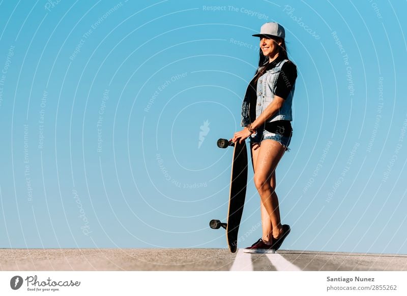 Schöne Skaterin, die mit ihrem Longboard posiert. Mädchen Frau Schlittschuhlaufen Stadt Jugendliche Sport Skateboarding Stil Reiten Schlittschuhe Glück Lächeln