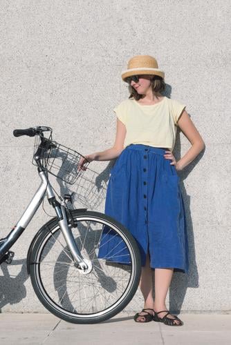 Junges sexy blondes Mädchen steht in der Nähe des Fahrrads. Erwachsene Hintergrundbild Tasche Korb schön Beautyfotografie blau braun Kaukasier Großstadt