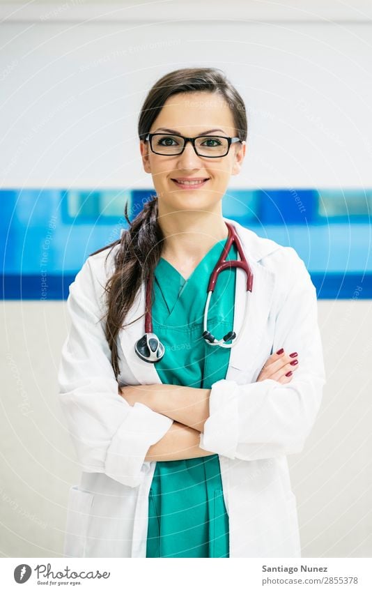 Lächelnd schöner Arzt im Krankenhaus. Stehend. Arme attraktiv Hintergrundbild Fürsorge Kaukasier heiter Klinikerin Gerät Frau Freundlichkeit Glück Gesundheit