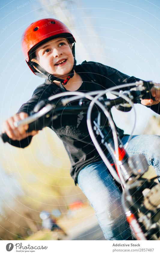 Junge ruht sich aus, nachdem er mit dem Fahrrad gefahren ist. Kaukasier Kind Landschaft niedlich Freude Glück Helm Lifestyle Außenaufnahme Park Reiten Sport