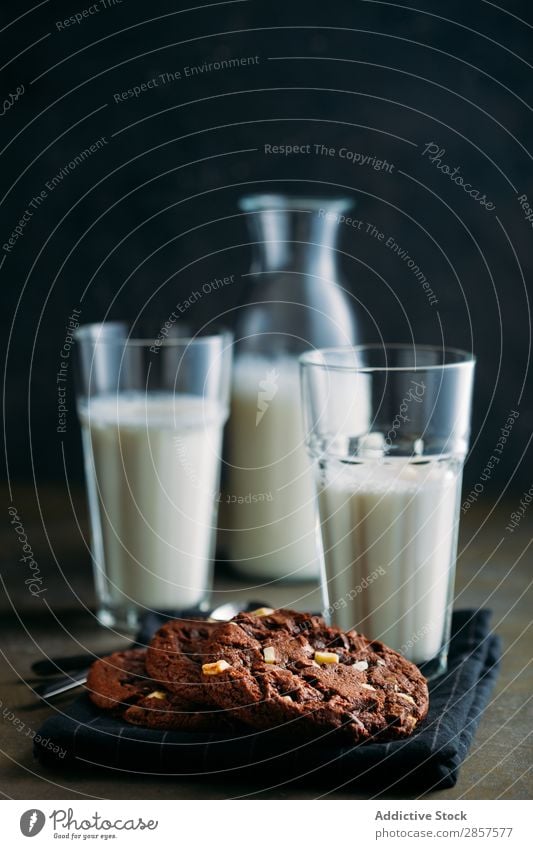 Schokoladenkekse und Milchgläser auf dunklem Hintergrund backen Flasche Frühstück Brownie Kuchen Kakao Plätzchen Kühlregal dunkel Dessert trinken Lebensmittel