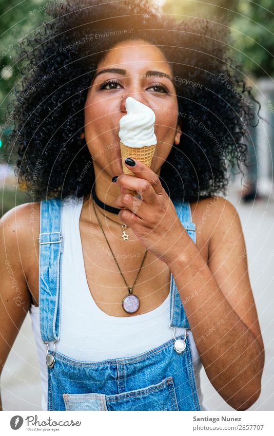 Porträt einer schönen Frau, die ein Eis isst. schwarz Afrikanisch Afro-Look Speiseeis Creme Essen lutschen Sommer heiß saugen Mensch Großstadt Jugendliche