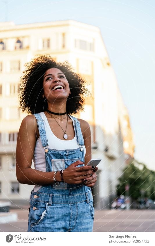 Schöne Frau mit Handy auf der Straße. Telefon schwarz Afrikanisch Mobile PDA Texten Mitteilung Afro-Look Mensch Porträt Großstadt Jugendliche Mädchen Amerikaner