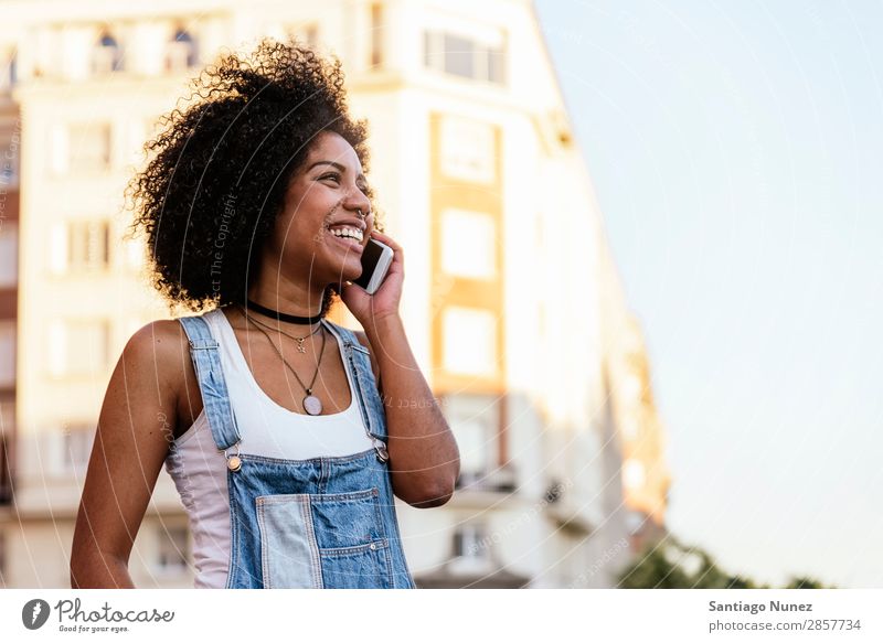 Schöne Frau mit Handy auf der Straße. Telefon schwarz Afrikanisch Mobile PDA Sprechen Afro-Look Mensch Porträt Großstadt Jugendliche Mädchen Amerikaner Lächeln