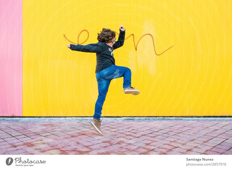 Fröhlicher Junge beim Springen. springen Kind Aufregung Stil Jugendliche Straße Stadt Freestyle Hintergrundbild Großstadt Mann Model Lifestyle Außenaufnahme