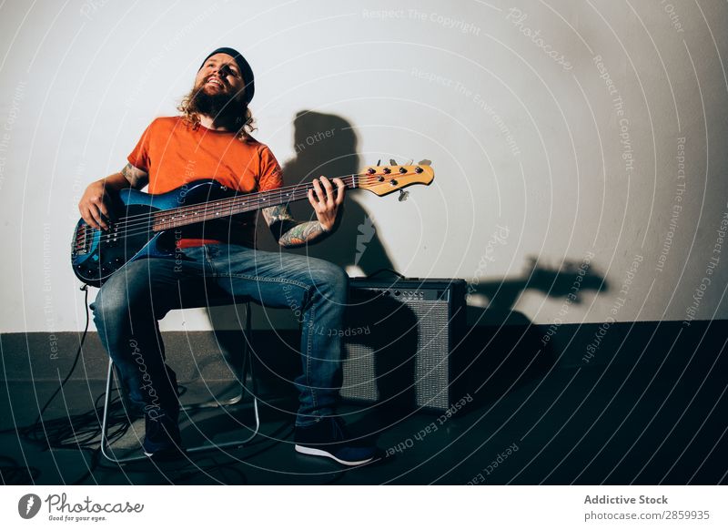 Cooler junger Mann beim Bass spielen akustisch alternativ Verstärker Künstler Band Konzert Elektrogitarre Entertainment Gitarre Gitarrenspieler Schickimicki