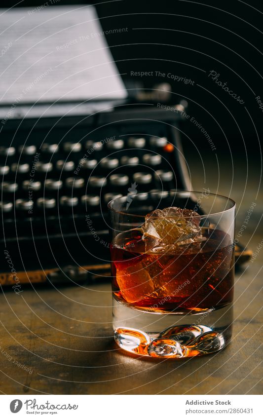 Ein Glas Whiskey und eine Retro-Schreibmaschine. Alkohol Amber analog Antiquität Getränk Bourbon Weinbrand Charakter klassisch Cognac Kreativität trinken gold