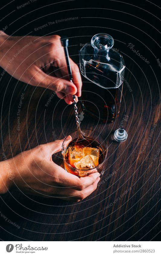 Ein Glas Whiskey auf einem Holztisch Alkohol Amber Hintergrundbild Bar Barmann Barkeeper Getränk Flasche Bourbon Weinbrand Cognac trinken gold Hand Eis