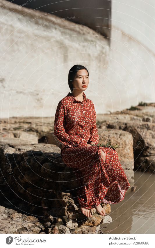 Hübsche asiatische Frau am Teich sitzend Jugendliche attraktiv Kleid rot Japaner Boden Fürsorge Wegsehen schön Beautyfotografie Mensch hübsch Dame Porträt Mode