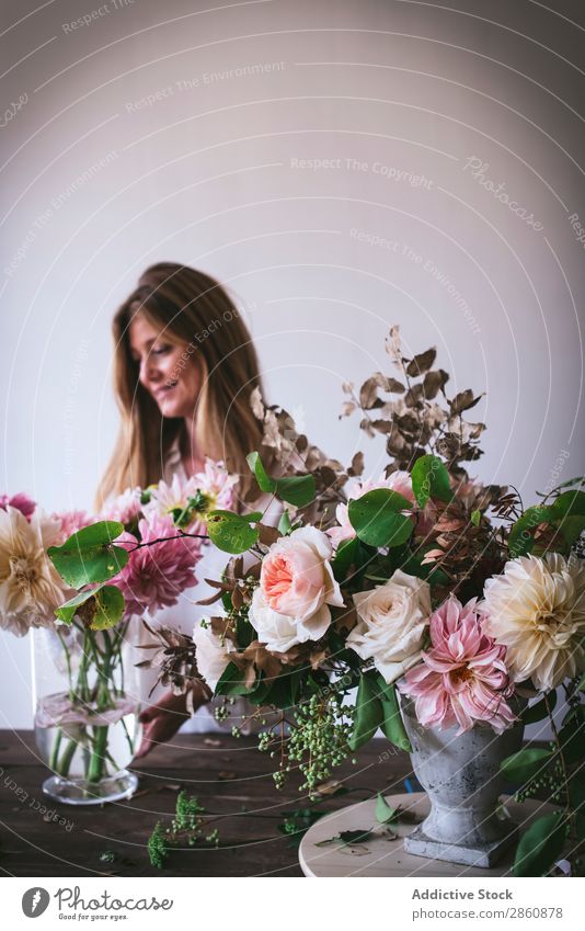 Frau am Tisch mit Blumensträußen in Vasen Blumenstrauß Pflanze Chrysantheme Rose Zweig Glück frisch Haufen Blatt Holz Dame Ast Blütenknospen Natur Kreativität