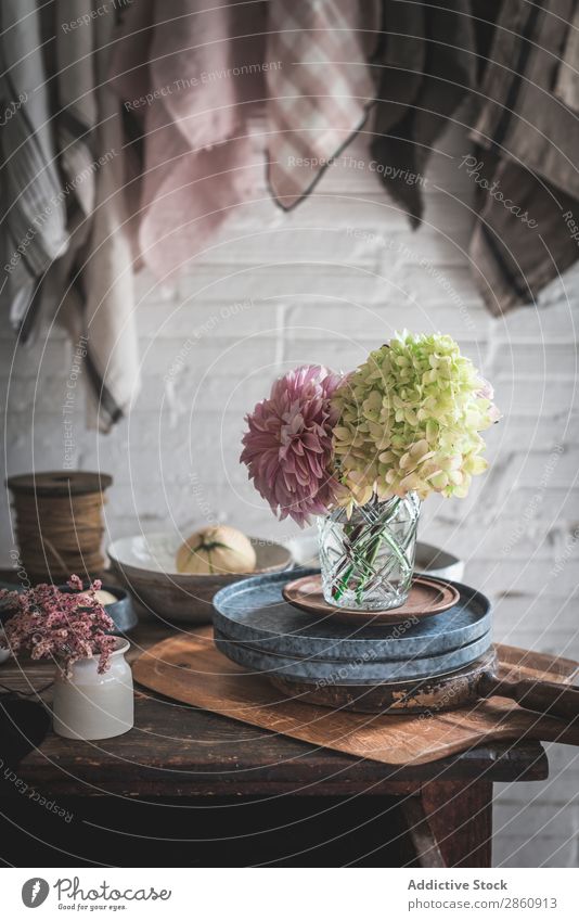 Tisch mit Blumen in Vase auf Tabletts neben Handtüchern, die am Garn hängen. Handtuch Faser erhängen Chrysantheme Hortensie Haufen Pflanze Pfanne Geschirrtuch