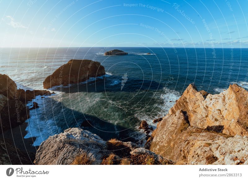 Hohe Klippe in Wassernähe an sonnigen Tagen Meer Cabo de Penas Asturien Spanien Hügel Stein Höhe Schönes Wetter Top malerisch Sonne Landschaft Küste blau