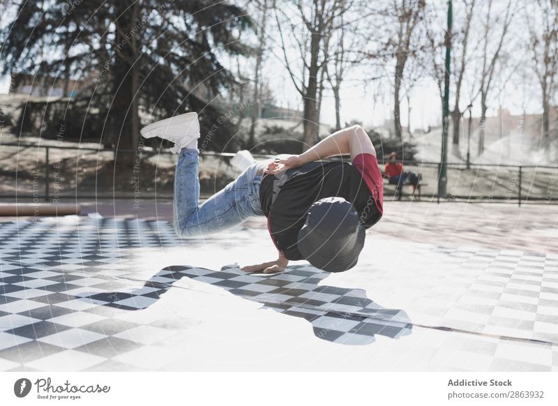 Mann tanzt Breakdance im Park Breakdancer Schönes Wetter Tanzen üben Stil sportlich Jeanshose Jugendliche Typ Sport Fitness Flexibilität Spielplatz Yoga