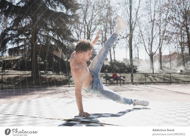 Hemdloser Mann tanzt Breakdance im Park Breakdancer Schönes Wetter Tanzen üben Stil sportlich Jeanshose Jugendliche Typ ohne Hemd Sport Fitness Flexibilität
