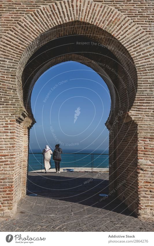 Bogen des Gebäudes und der Frauen, die die Meereslandschaft betrachten. Seeküste Zaun Tanger Marokko Himmel Konstruktion wunderbar Architektur Blick aussruhen