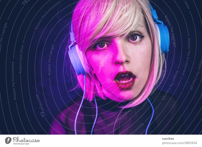 Junge Frau, die Musik hört und von Neonlichtern beleuchtet wird. Lifestyle schön Gesicht Leben Nachtleben Diskjockey Headset Technik & Technologie