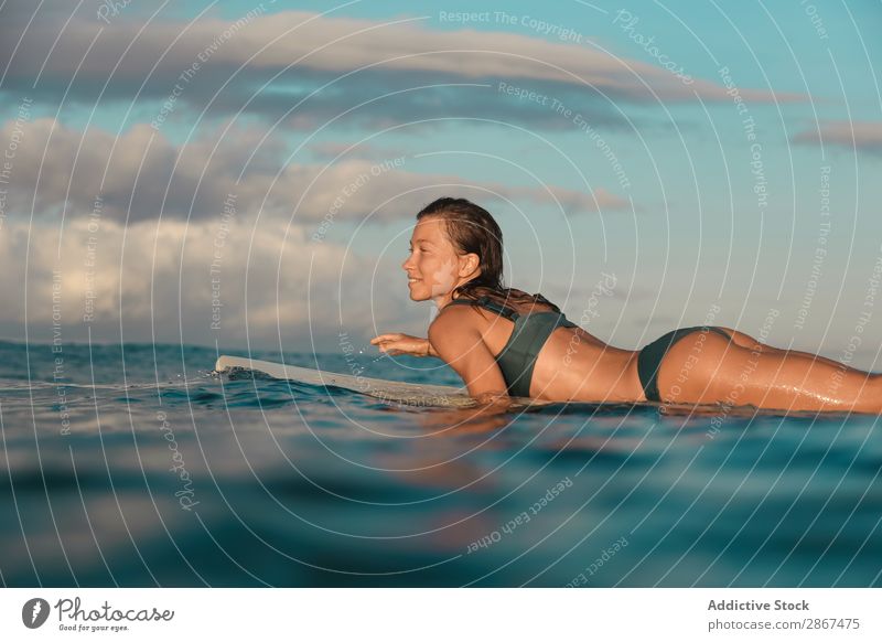 Frau auf dem Surfbrett schwimmend auf dem Wasser Sport Bali Indonesien Surfen winken fliegend blau Lächeln Meer Oberfläche Himmel (Jenseits) heiter