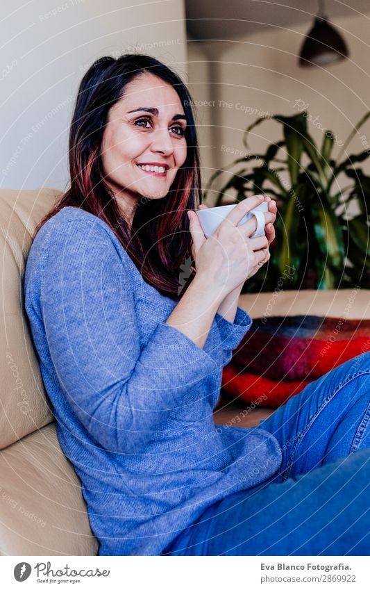 junge kaukasische Frau beim Kaffee zu Hause Frühstück Getränk Tee Lifestyle Glück Freizeit & Hobby Sofa Mensch feminin Junge Frau Jugendliche Erwachsene 1