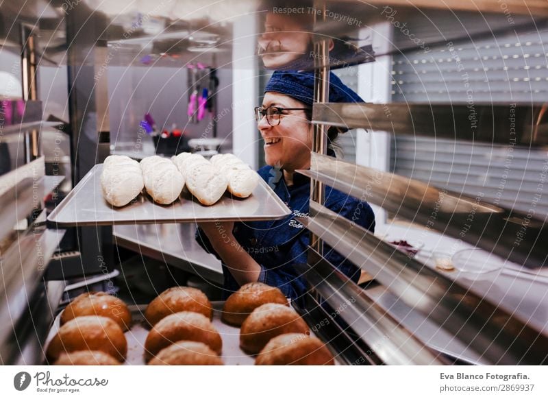 Frau mit einem Brötchenregal in einer Bäckerei. Brot Glück Küche Restaurant Schule Arbeit & Erwerbstätigkeit Beruf Fotokamera feminin Erwachsene 1 Mensch