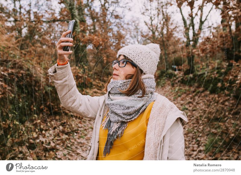 eine junge Frau schaut auf das Handy im Wald. Lifestyle schön Ferien & Urlaub & Reisen Abenteuer wandern Telefon Bildschirm Technik & Technologie Mensch