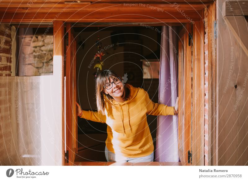eine junge Frau in einem gelben Sweatshirt öffnet das Fenster. Lifestyle Stil Freude Glück schön Erholung Freizeit & Hobby Ferien & Urlaub & Reisen Winterurlaub