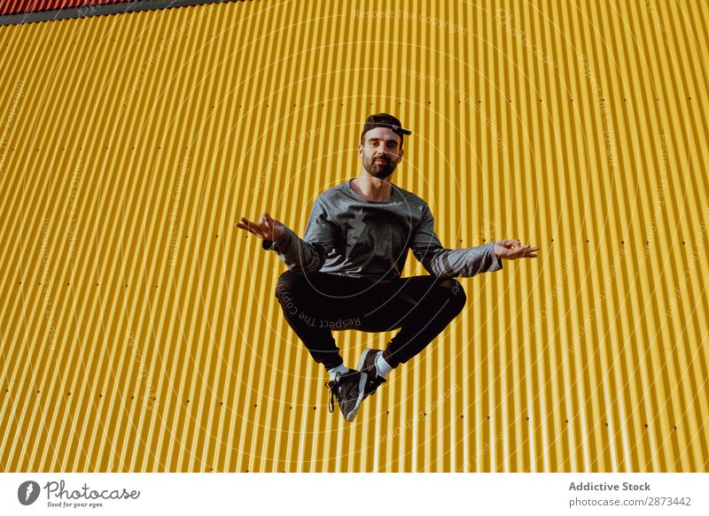 Mann springt an der gelben Wand vorbei Straße springen Gebäude Stunt Stil lässig trendy Fitness Aktion Großstadt Lifestyle Freizeit & Hobby üben Stadt