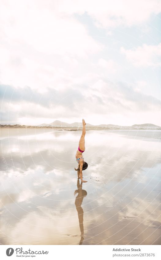 Frau beim Handstand am Meer Badebekleidung Sand nass Barfuß üben dünn Fitness Training Sport Wasser Dame Bikini Jugendliche Himmel Yoga Pose Strand