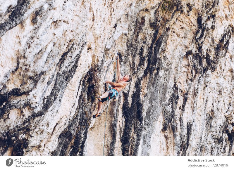 Anonymer Mann klettert auf den Felsen Klettern Klippe extrem Sport Herausforderung Aktion Erfolg Kraft Höhe erhängen Seil Abenteuer Risiko sichern