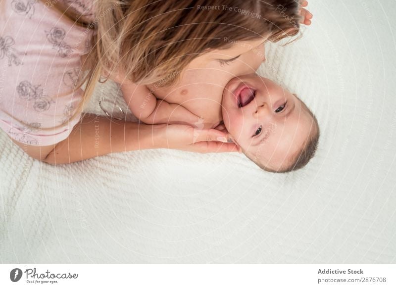 Frau spielt mit dem kleinen glücklichen Baby im Bett. Down-Syndrom Mutter neugeboren Spielen Raum lustig Glück lügen nackt Fürsorge Mama heimwärts Kind