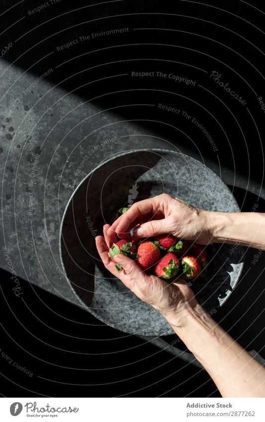 Hände mit Erdbeerhaufen auf dem Teller Hand Erdbeeren Haufen frisch Anhäufung Schalen & Schüsseln Sonnenstrahlen Dunkelheit erleuchten Frucht Lebensmittel süß