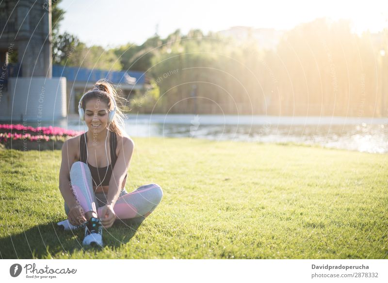 Sportlerin bei Rasenübungen und Dehnübungen auf dem Rasen in einem Park mit Musik Frau Yoga Pilatus Fitness strecken Übung Gras Sonnenuntergang Mädchen jung