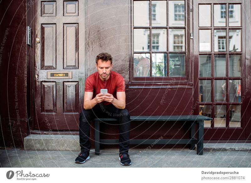Mann sitzt auf einer Bank auf einem schönen kastanienbraunen Hintergrund. Handy Kaukasier Gebäude Jugendliche Architektur Technik & Technologie altehrwürdig