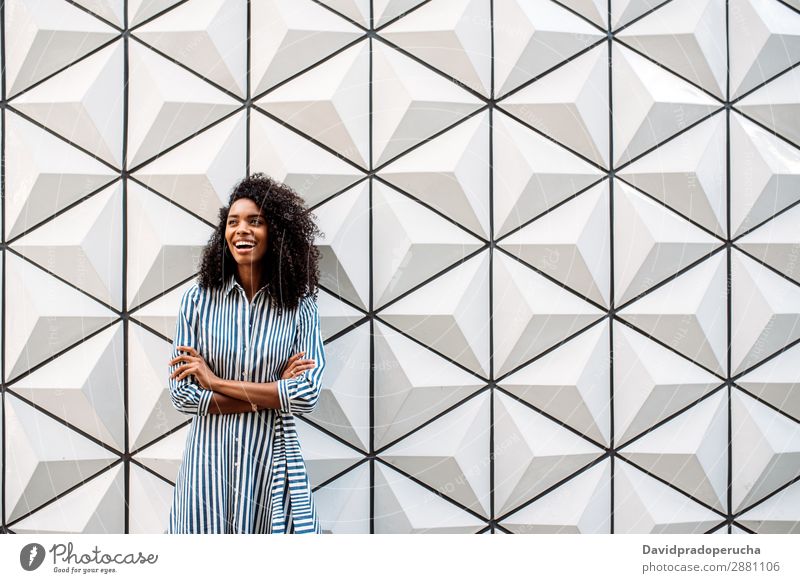 Glückliche hübsche Frau, die lächelnd wegguckt. Architektur Afrikanisch schwarz Jugendliche urwüchsig Gebäude Lächeln Porträt Hintergrundbild modern