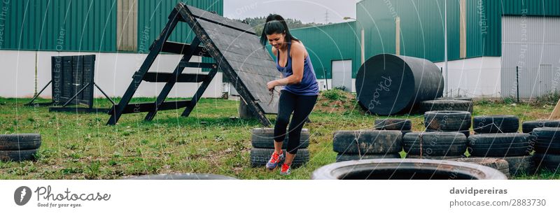 Frau im Hindernislauf, die Räder zieht Freude Glück Sport Internet Mensch Erwachsene Gras Lächeln authentisch stark Kraft Einsamkeit anstrengen Panorama