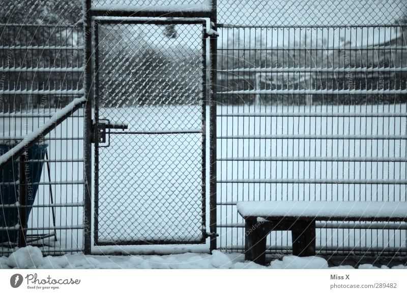 Winter Sportstätten Fußballplatz Rennbahn Schnee kalt trist grau Tür Metallzaun Maschendrahtzaun Gedeckte Farben Außenaufnahme Muster Menschenleer