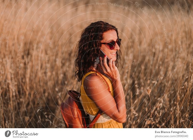 Junge schöne Frau in gelbem Kleid im Gespräch mit dem Handy Lifestyle Glück Körper Ferien & Urlaub & Reisen Sommer Sonne Telefon Technik & Technologie Internet