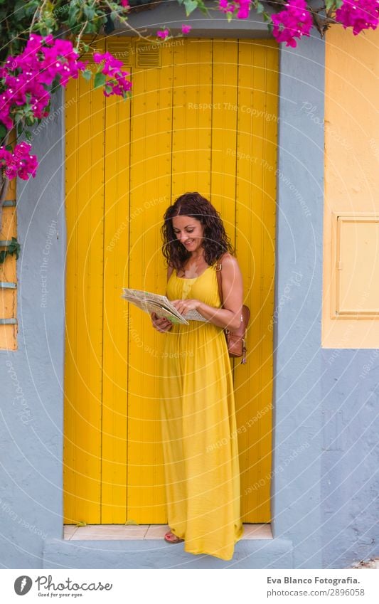 Junge Touristenfrau im gelben Kleid, die auf einer Karte aussieht. Glück Ferien & Urlaub & Reisen Tourismus Ausflug Sightseeing Telefon Mensch feminin