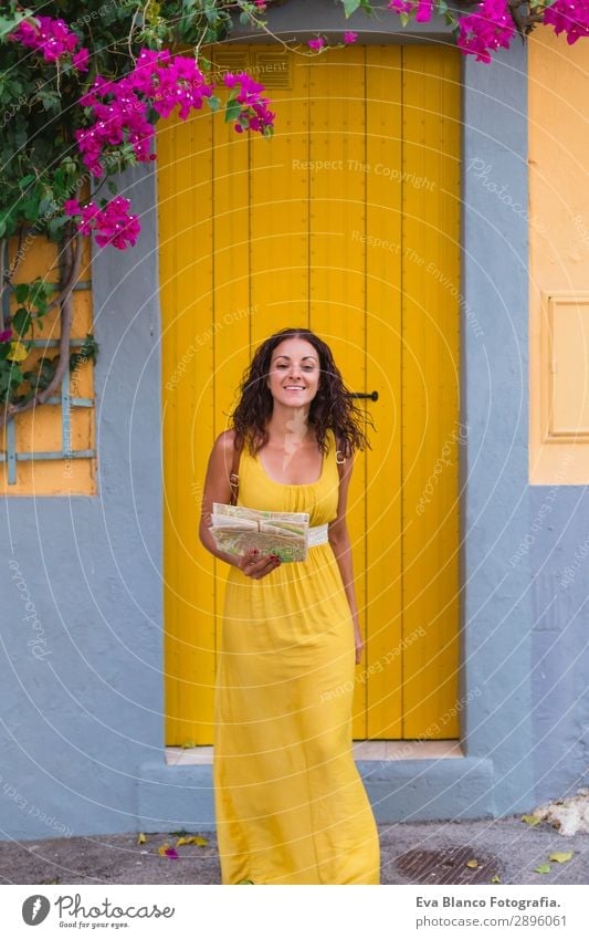 Junge Touristenfrau in gelbem Kleid lächelnd und auf einer Karte schauend. Glück Ferien & Urlaub & Reisen Tourismus Ausflug Sightseeing Telefon Mensch