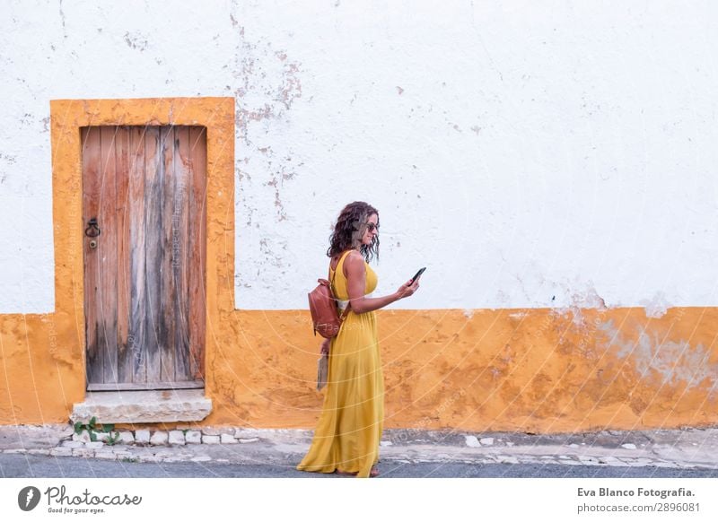 Junge Frau in gelbem Kleid geht durch die Stadt. Glück Ferien & Urlaub & Reisen Tourismus Ausflug Sightseeing Telefon Mensch feminin Jugendliche Erwachsene 1