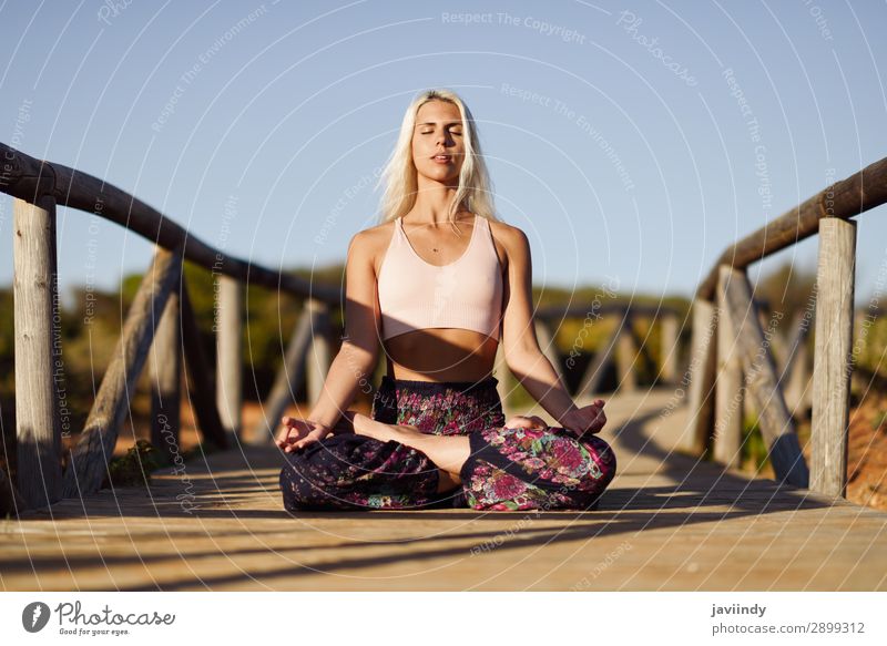 Kaukasische Frau beim Yoga auf einer Holzbrücke. Lifestyle Glück schön Körper harmonisch Erholung Meditation Freiheit Sommer Sonne Strand