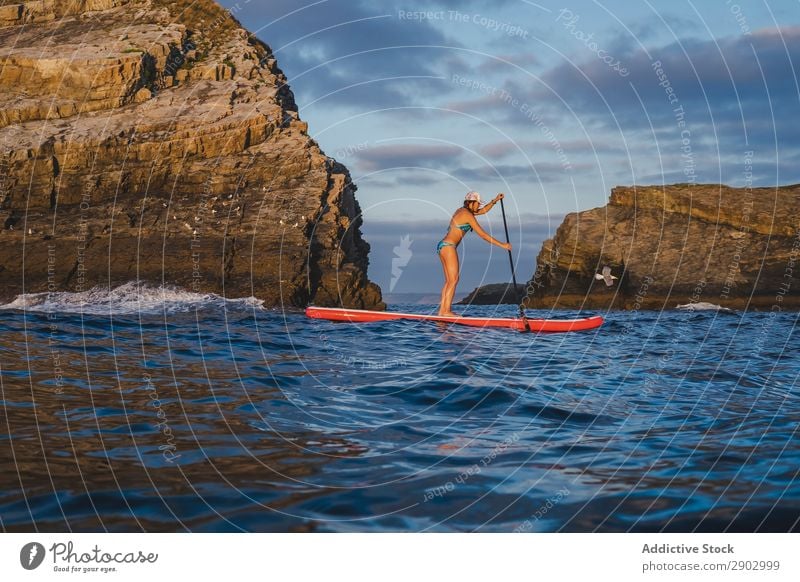 Frau auf dem Paddelbrett, die im Meer schwimmt. Paddelboarden Rudern Himmel Wolken Freizeit & Hobby Sport Wasser Ferien & Urlaub & Reisen Lifestyle