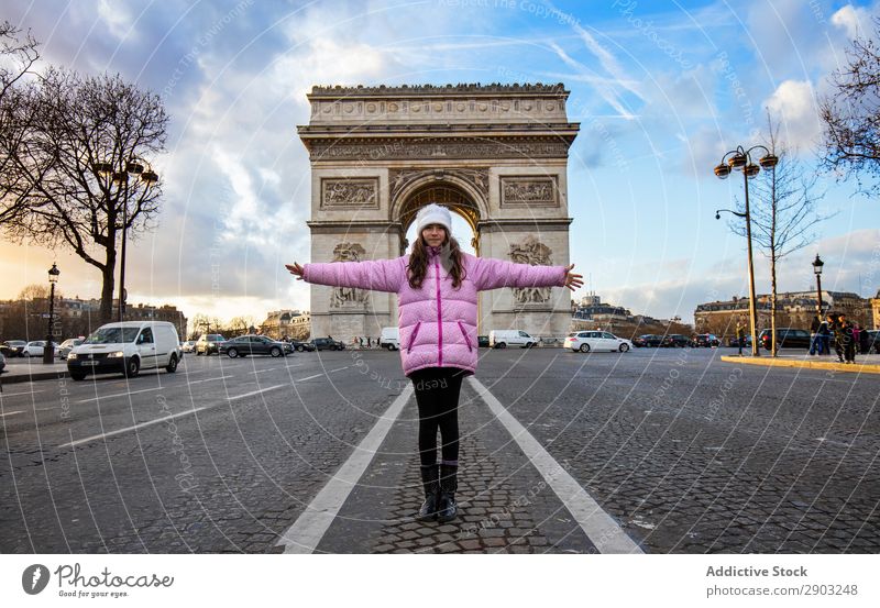 Mädchen steht gegen Triumphbogen Triumph Bogen Straße ausgestreckte Arme Tourismus Großstadt Himmel Wolken Freiheit gestikulieren Jugendliche