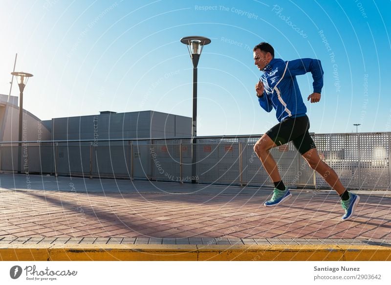 Ein gutaussehender Mann, der in der Stadt herumläuft. rennen Joggen Läufer Straße Großstadt Athlet Geschwindigkeit Fitness Lifestyle Jugendliche Aktion Schatten