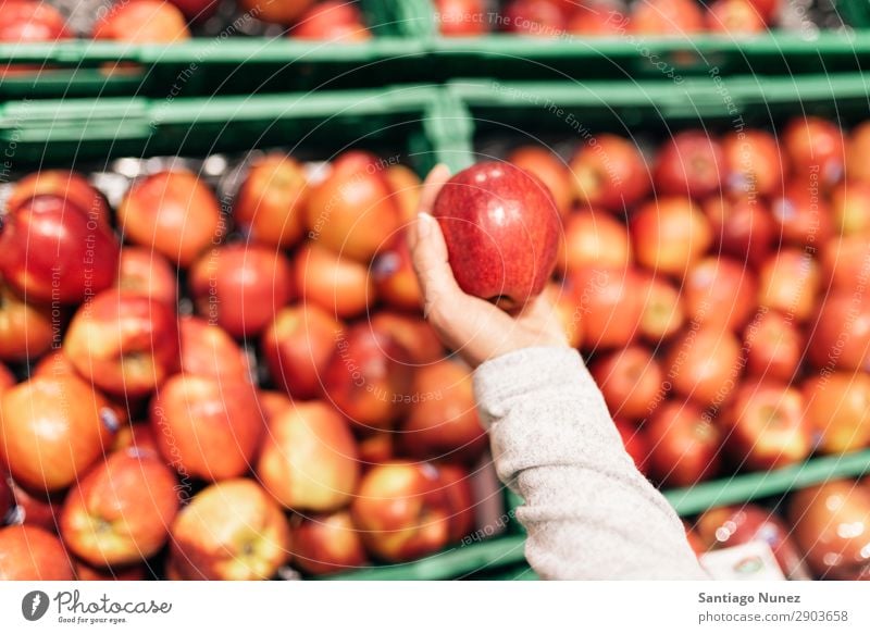 Schöne Frau, die Äpfel im Supermarkt auswählt. Frucht Nahaufnahme Lager Mensch Apfel Markt auserwählend Lebensmittel Hand Gesundheit frisch Halt kaufen