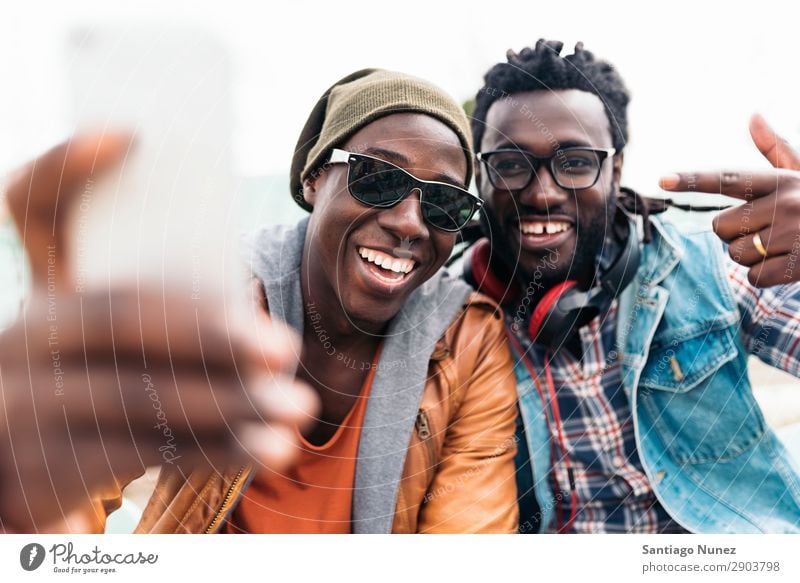 Zwei schwarze Rassenfreunde, die Spaß haben. Freundschaft Telefon Handy Stadt Afrikanisch Amerikaner Mobile Jugendliche Mann lachen PDA Technik & Technologie