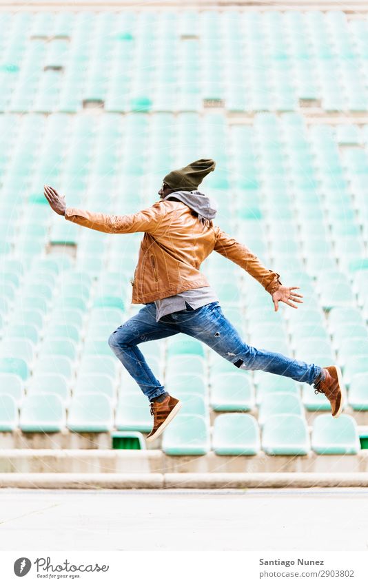 Ein amerikanischer Mann, der in den Park springt. Telefon Stadt springen handelnd Afrikanisch schwarz Amerikaner Jugendliche Mensch Glück Fröhlichkeit Lächeln