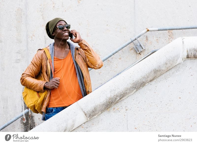 Ein amerikanischer Mann, der ein Handy auf der Straße benutzt. Telefon Stadt Afrikanisch schwarz Amerikaner Mobile Jugendliche lachen PDA Technik & Technologie