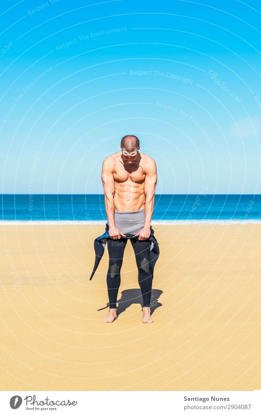 Schwimmer zieht seinen Neoprenanzug am Strand an. Bauchmuskeln attraktiv schwarz Körper Kaukasier Taucher tauchen üben sportlich Fitness Brillenträger